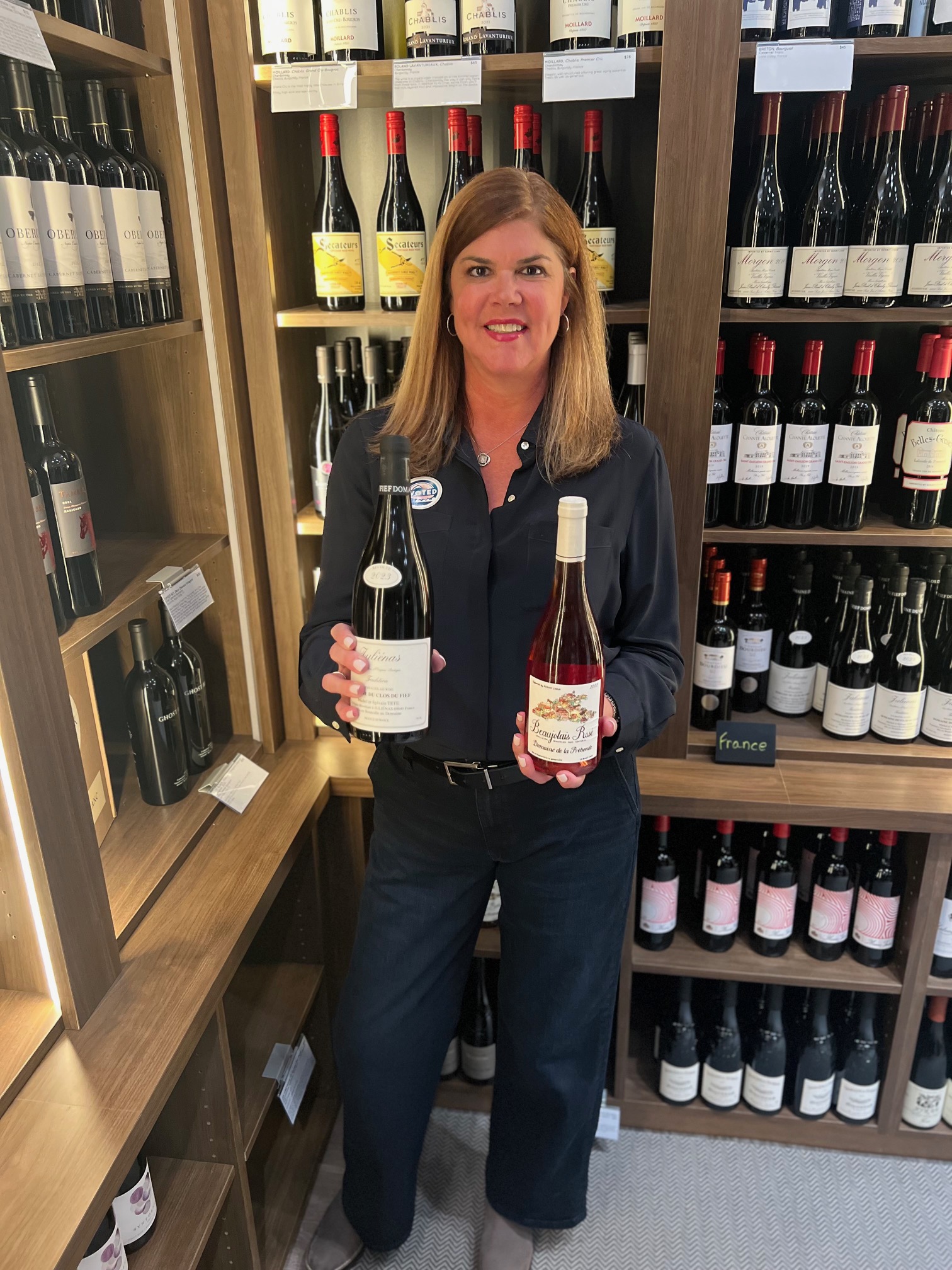 Jennifer Walker at Zephyr Wine Bar with bottles of Beaujolais 